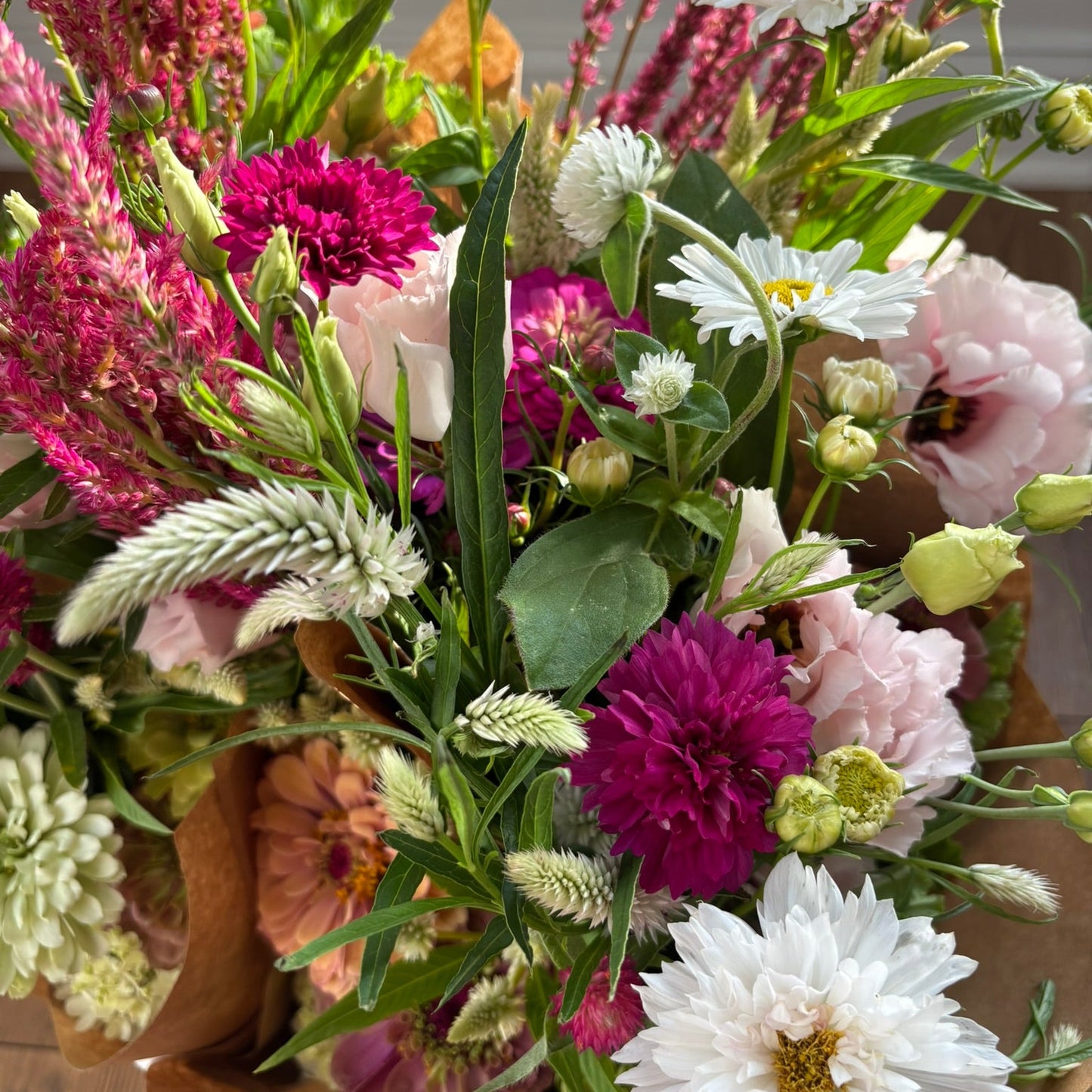 Bouquet of colorful flowers including white, pink, and purple blooms with green leaves.