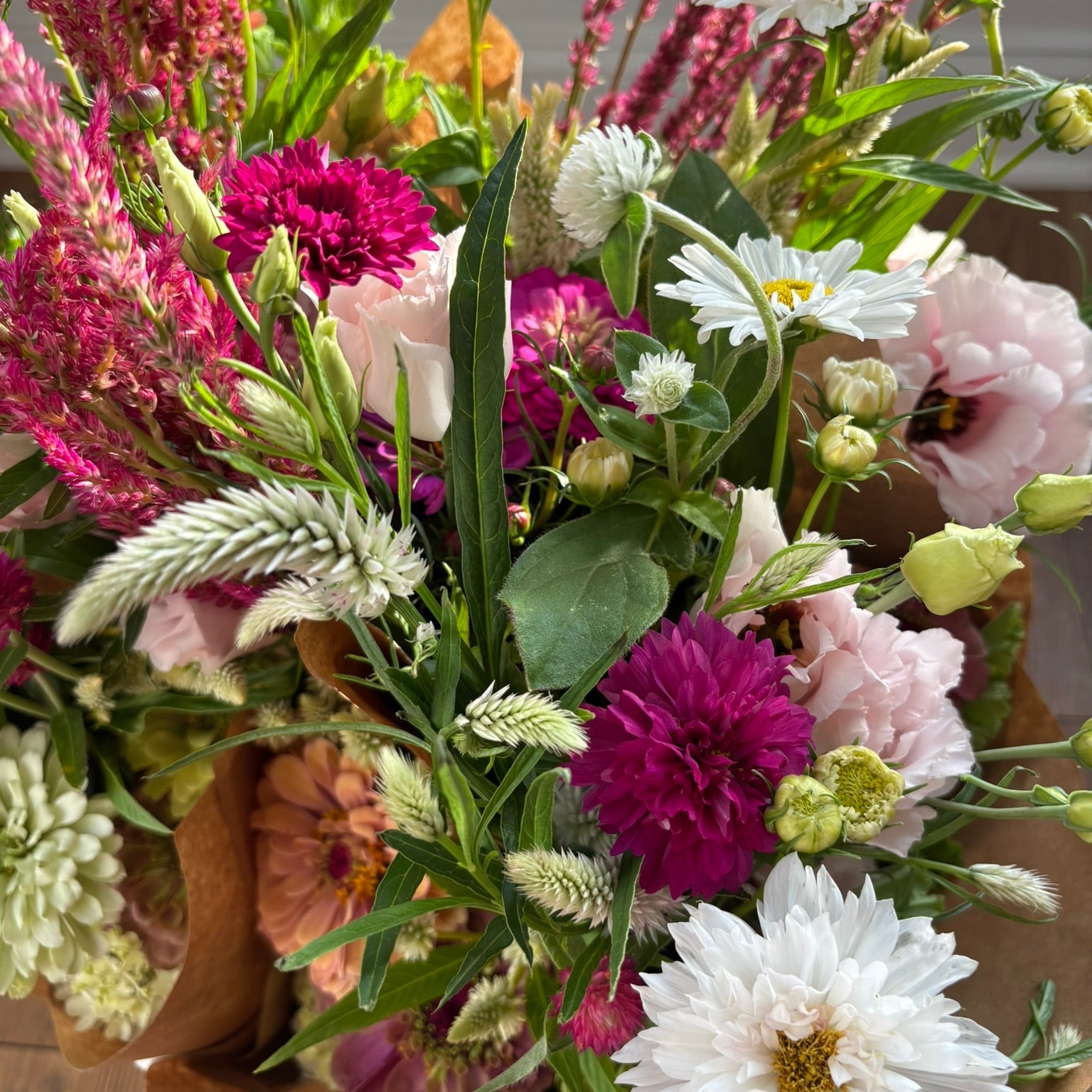 Bouquet of colorful flowers including white, pink, and purple blooms with green leaves.